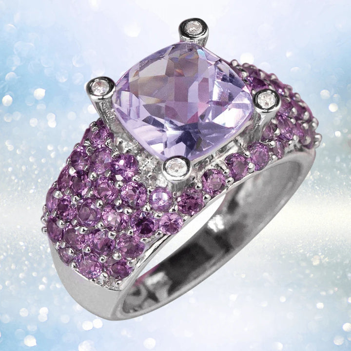 Antoinette Ring featuring a sterling silver band adorned with purple gemstones and a large cushion-cut lavender center stone, designed for women’s jewelry.