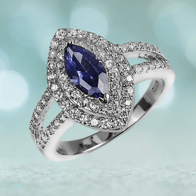 Constantina Ring featuring a marquise-cut blue gemstone surrounded by sparkling white stones, crafted in rhodium-plated sterling silver for women’s jewelry.