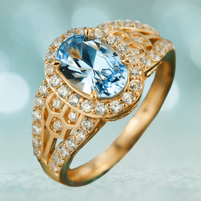 Sky Honeycomb Ring featuring a sterling silver base with gold plating, designed for women, showcasing a large oval blue gemstone surrounded by sparkling clear crystals in a honeycomb pattern.