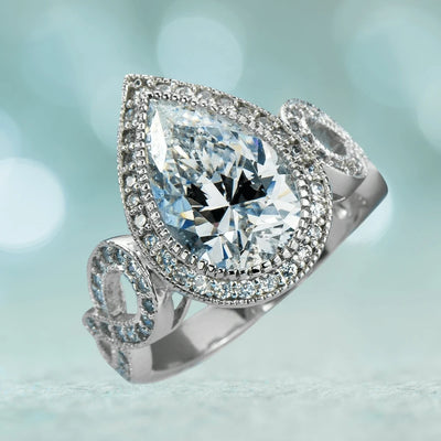 Marie Anna Teardrop Rhodium Ring featuring a sterling silver band with rhodium plating and a large teardrop-shaped clear gemstone surrounded by smaller sparkling stones, designed for women.