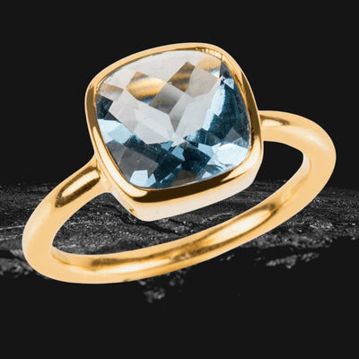 Dream Gems Ring Blue Topaz featuring a sterling silver band plated with gold, showcasing a cushion-cut blue topaz gemstone designed for female jewelry lovers.
