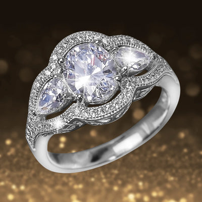 Bellissima Ring featuring sterling silver with rhodium plating, adorned with a large central gemstone flanked by two pear-shaped stones and surrounded by smaller sparkling accents.