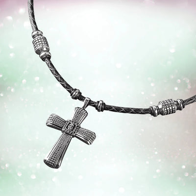 Midnight Skull Steel Pendant featuring a sterling silver cross pendant on a braided black leather necklace, designed for male jewelry enthusiasts.