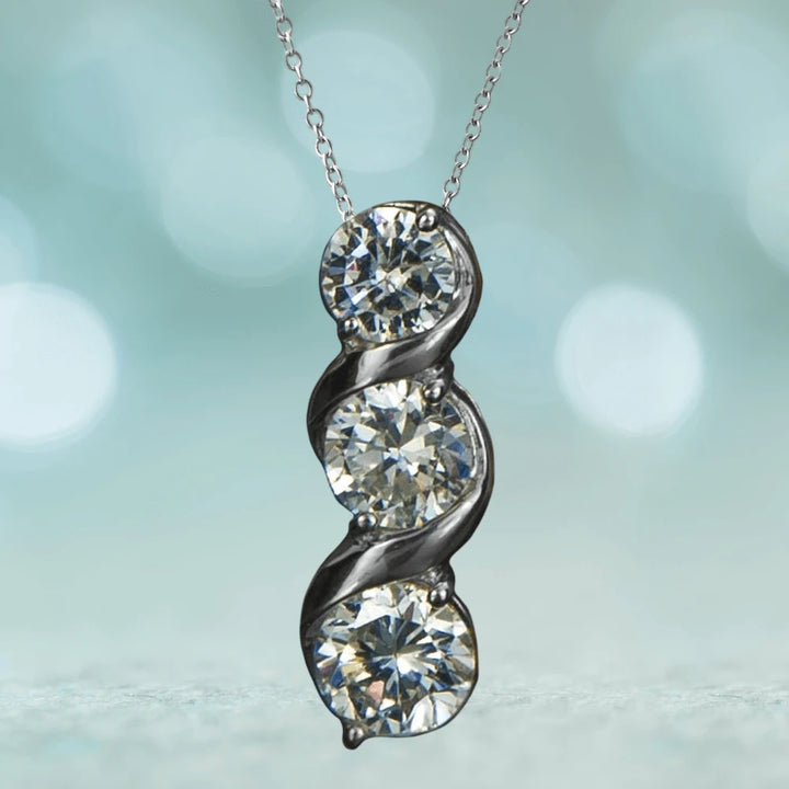 Solitaire Twist Pendant featuring three sparkling stones set in sterling silver with rhodium plating, designed for a sophisticated female jewelry collection.