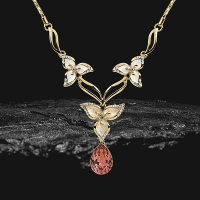 Calla Flora Necklace in gold plating featuring an elegant floral design with white enamel accents and a teardrop-shaped pink gemstone pendant.