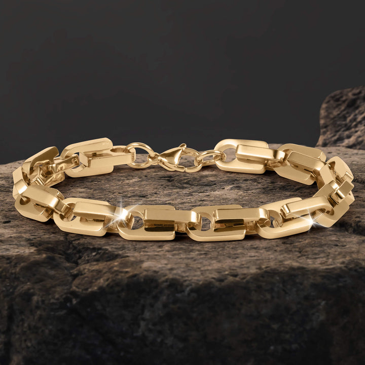 Moderna Link Bracelet with polished gold tone interlocking links and a secure clasp displayed on textured stone for a refined jewelry presentation