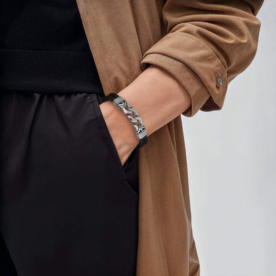 Horizon Men's Black Bracelet featuring a black leather band with silver chain accents worn on a male wrist paired with a brown coat and black pants.