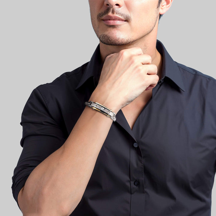 Man wearing a two-tone steel and leather Men's Diamond Leather Bracelet, dressed in a black shirt, showcasing the bracelet's elegant design.