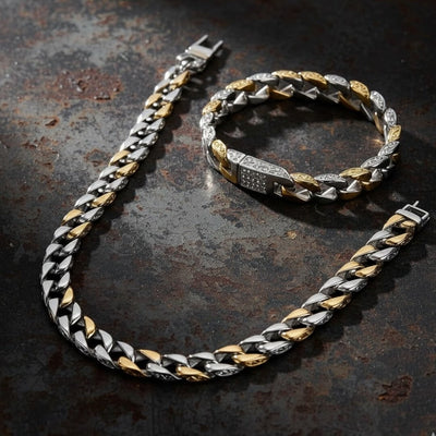 Bracelet with gold and silver chain on a textured dark surface.  Curb Vine Men's Set by Daniel Steiger