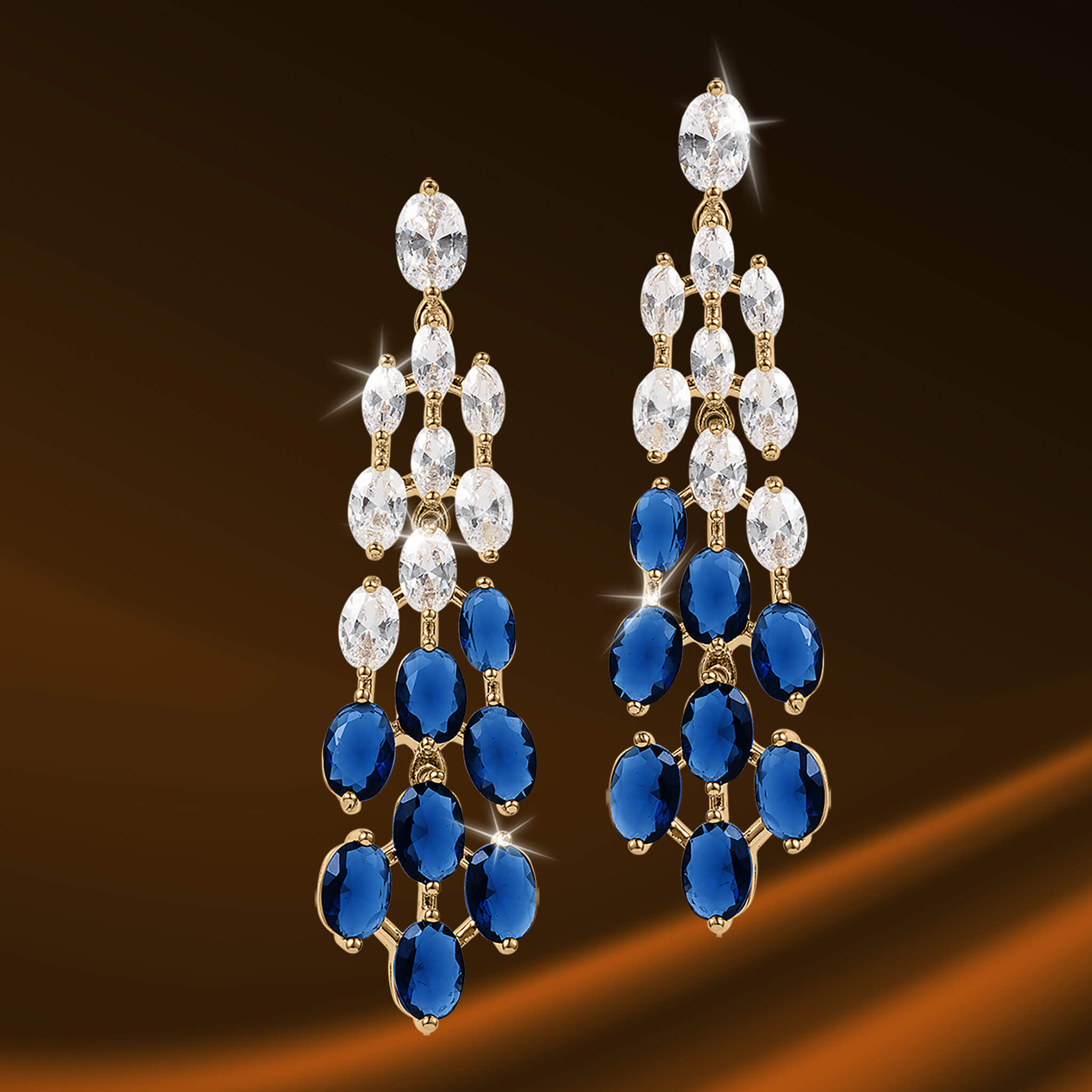 Elegant Royal Tide Earrings featuring cascading clear and deep blue gemstones set in gold-tone metal for a sophisticated jewelry statement.