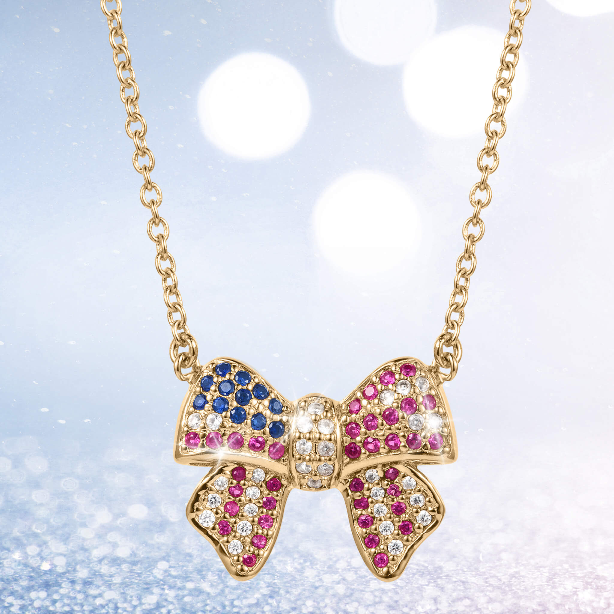 Delicate gold bow-shaped pendant adorned with blue, pink, and white gemstones on a fine chain, part of the Heritage Bow Collection jewelry.