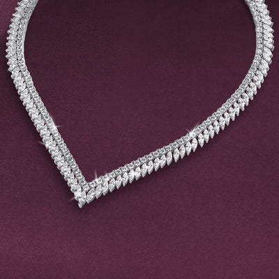 Crystal Cascade Necklace featuring a sparkling silver tone V shaped design with rows of clear faceted stones on a rich burgundy background Up To 75% Off Retail