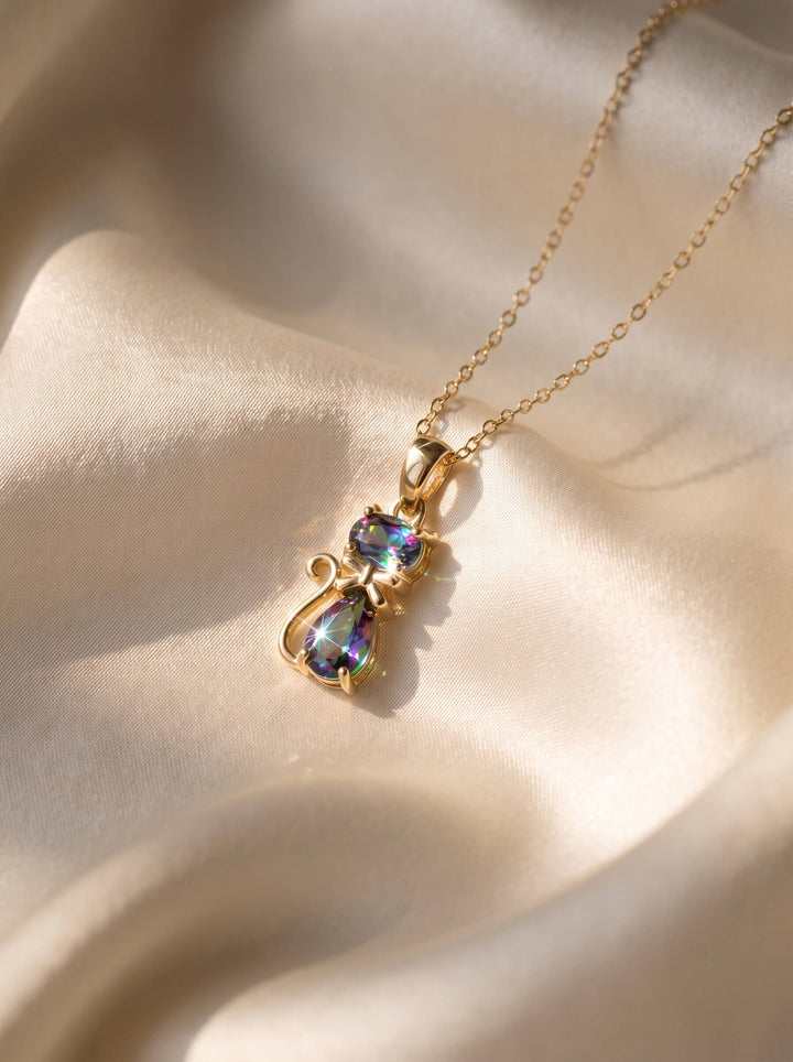 Mystic Kitten Pendant with a colorful jeweled kitten charm on a delicate gold tone necklace, displayed on softly draped satin, Up To 75% Off Retail