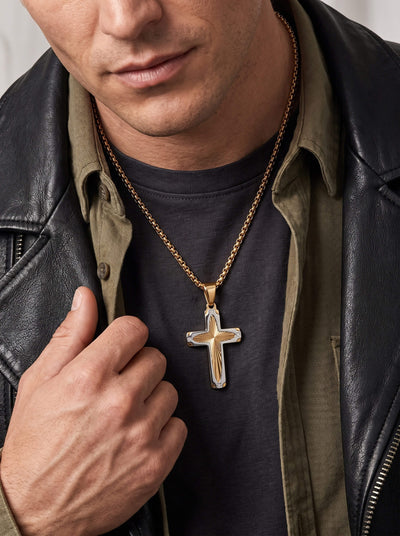 Guiding Light Cross Pendant worn on a gold tone chain over a dark shirt beneath a black leather jacket