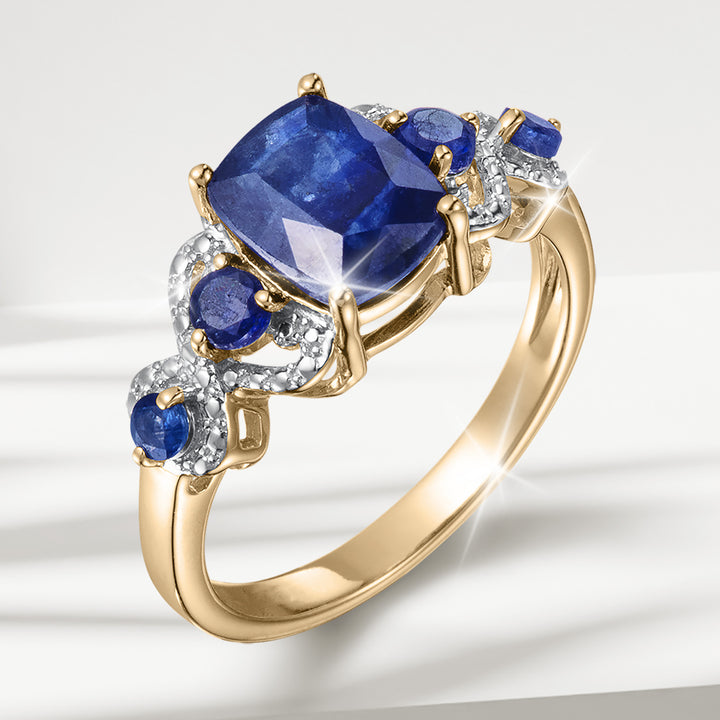 Elara Sapphire Collection gold ring featuring a large blue sapphire surrounded by smaller sapphires and diamond accents Up To 75% Off Retail