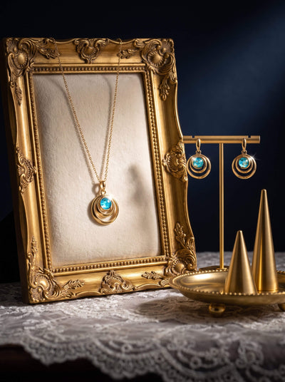 Baltic Lagoon Earrings featuring turquoise blue circular drops on a gold display stand beside a matching pendant in an ornate vintage frame