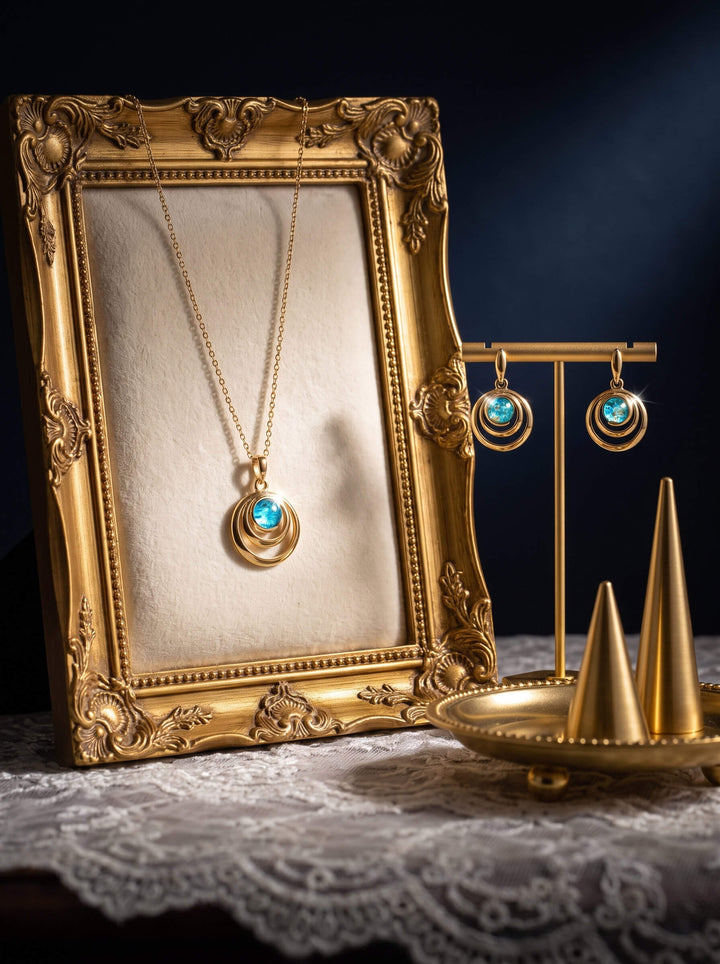 Baltic Lagoon Earrings featuring turquoise blue circular drops on a gold display stand beside a matching pendant in an ornate vintage frame