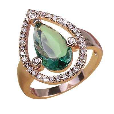 Peardrop Ring featuring a sterling silver band with a pear-shaped green gemstone centerpiece surrounded by sparkling clear stones, designed for women’s jewelry collections.