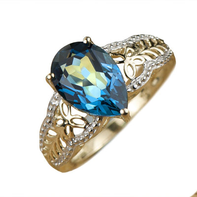 Parade Topaz Ring featuring a pear-shaped blue topaz set in sterling silver with gold plating, designed for a refined female jewelry collection.