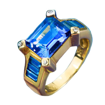 Cleopatra Topaz Ring featuring a large rectangular blue topaz centerpiece set in gold-plated sterling silver with additional blue topaz accents and small diamond details, designed for women.